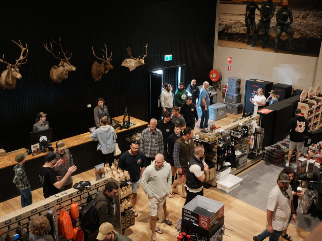 Items on display using slatwall gondolas, hooks and black mdf shelves in a hunting store.