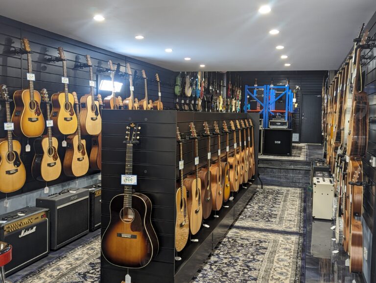 Music instruments on display in music shop using Dinya slatwalls and slatwall accessories.