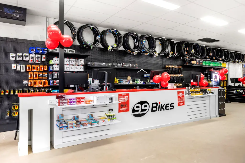 Interior view of a 99 Bikes store featuring bicycles, cycling gear, and accessories on display.