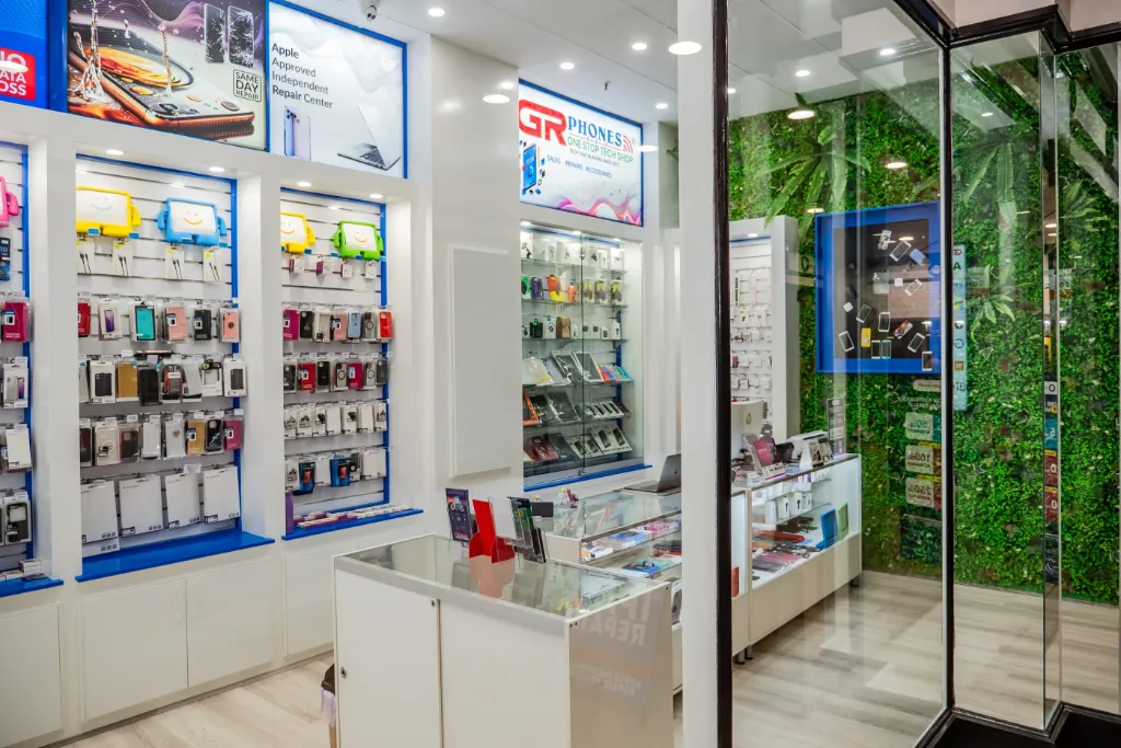 Wide view of the GR Phones Adelaide CBD store featuring white slatwall panels, mobile accessories displays, glass display cabinets, and retail counters.