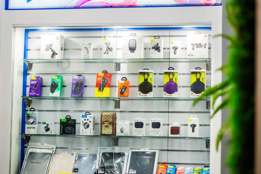 White slatwall panel with adjustable hooks displaying mobile phone accessories and electronics at GR Phones Adelaide CBD.