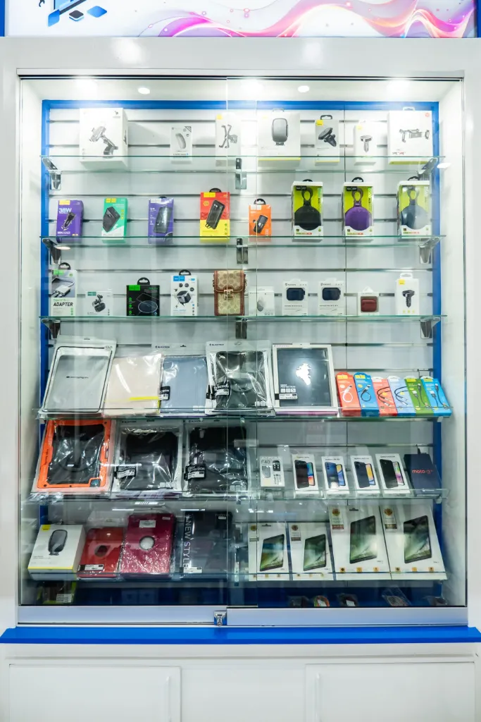 White slatwall panels with hooks displaying phone cases, chargers, cables and mobile accessories at GR Phones Adelaide CBD.