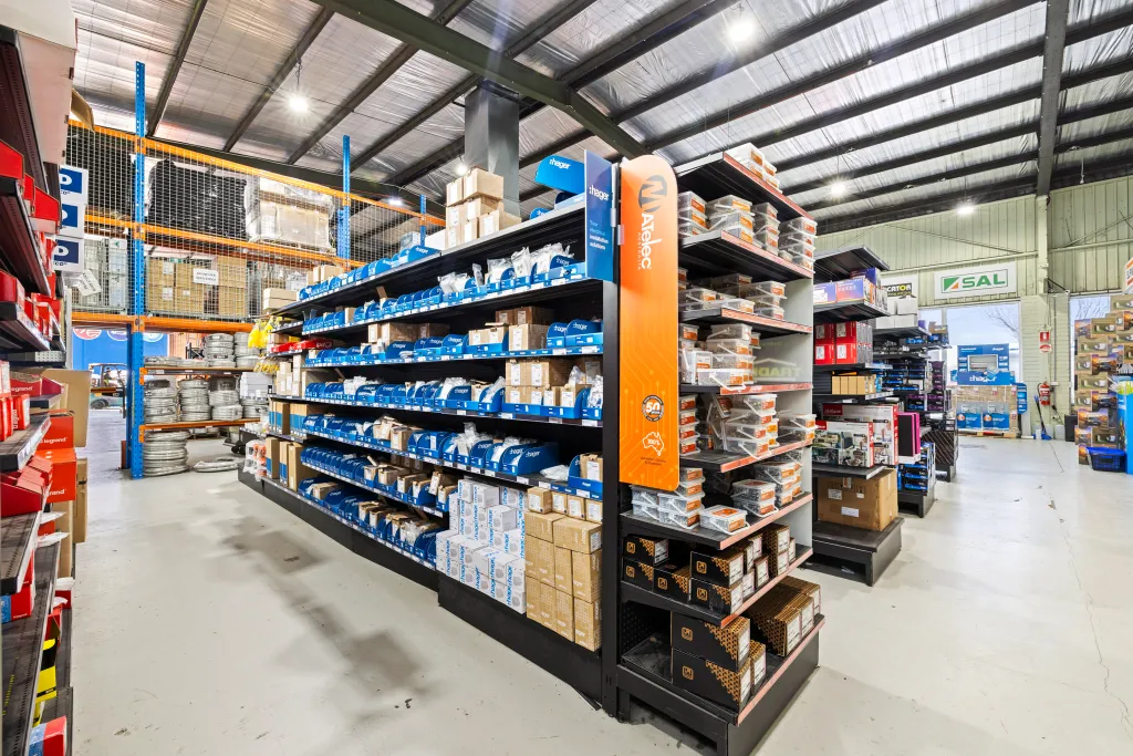 Black volcano board gondola shelving with adjustable shelves displaying electrical products in the AWM Airport West trade warehouse.