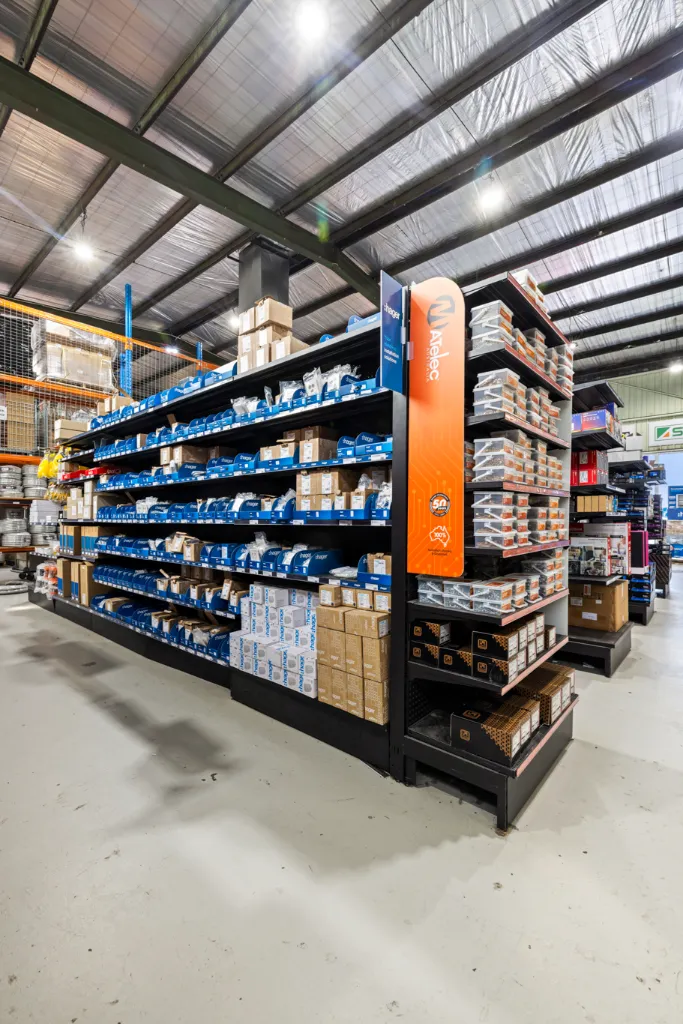 Black volcano board gondola shelving with adjustable shelves displaying organised electrical products in the AWM Airport West trade warehouse.