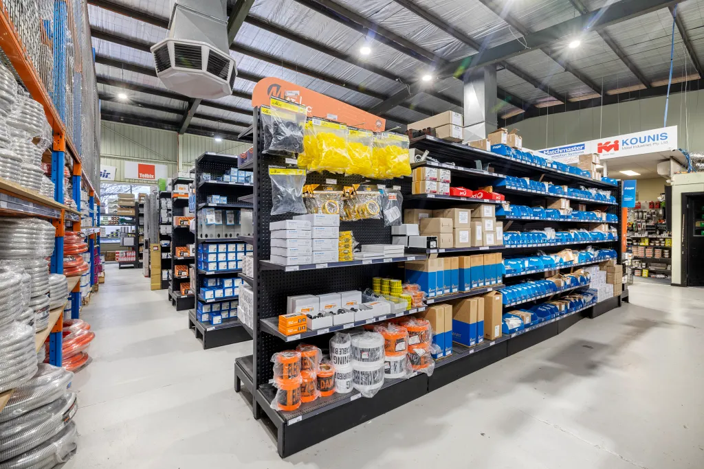 Black volcano board gondola shelving with adjustable shelves, hooks, and electrical products in the AWM Airport West trade warehouse.