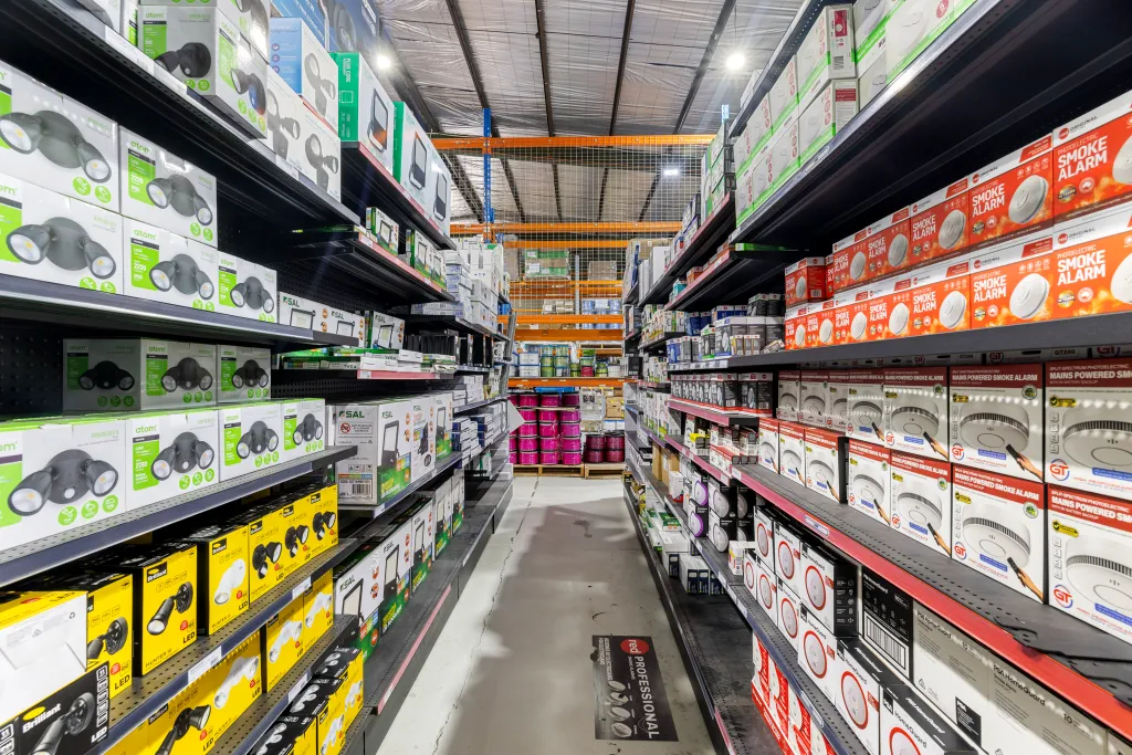 Trade warehouse aisle with black volcano board gondola shelving and organised electrical products at AWM Airport West.