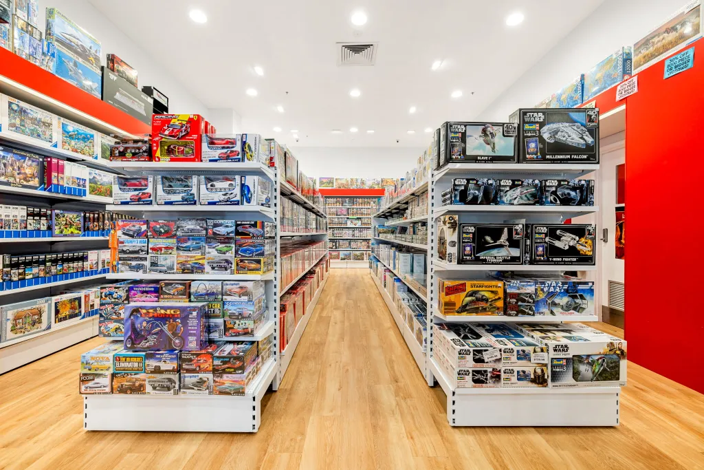 Games World Doncaster store aisle featuring white plain panel gondola shelving with organised displays of board games, puzzles, toys, and collectibles in Melbourne.