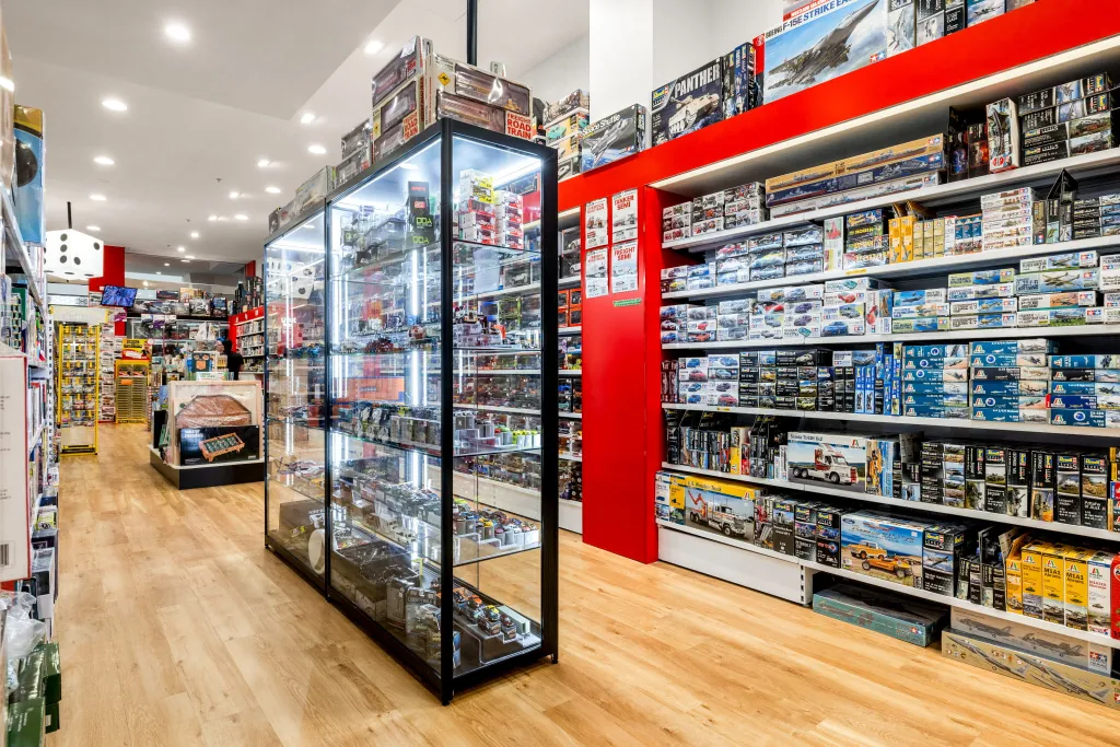 Glass display cabinets showcasing premium collectibles, model kits, and specialty games at Games World Doncaster in Melbourne.