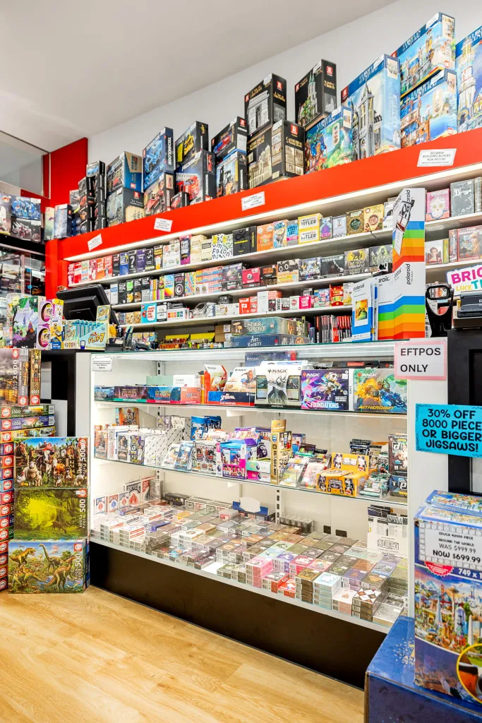 White wall shelving displaying collectible figures, model kits, and premium merchandise at Games World Doncaster.